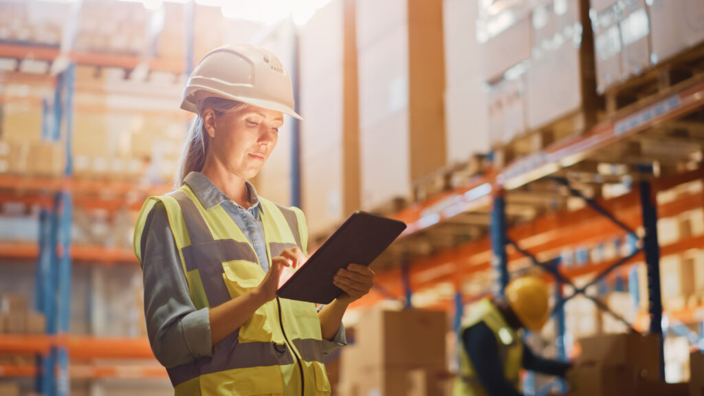Woman holding a tablet in a shipping warehouse