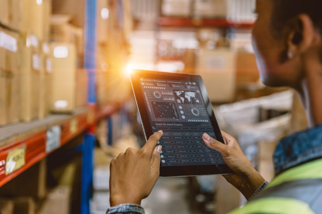 Woman using a tablet in a warehouse to process an e-commerce order for shipping